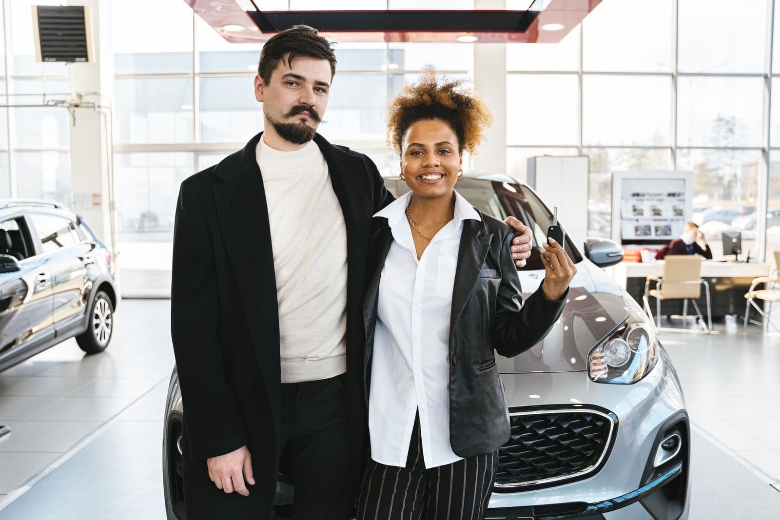 A couple with their new car in a showroom